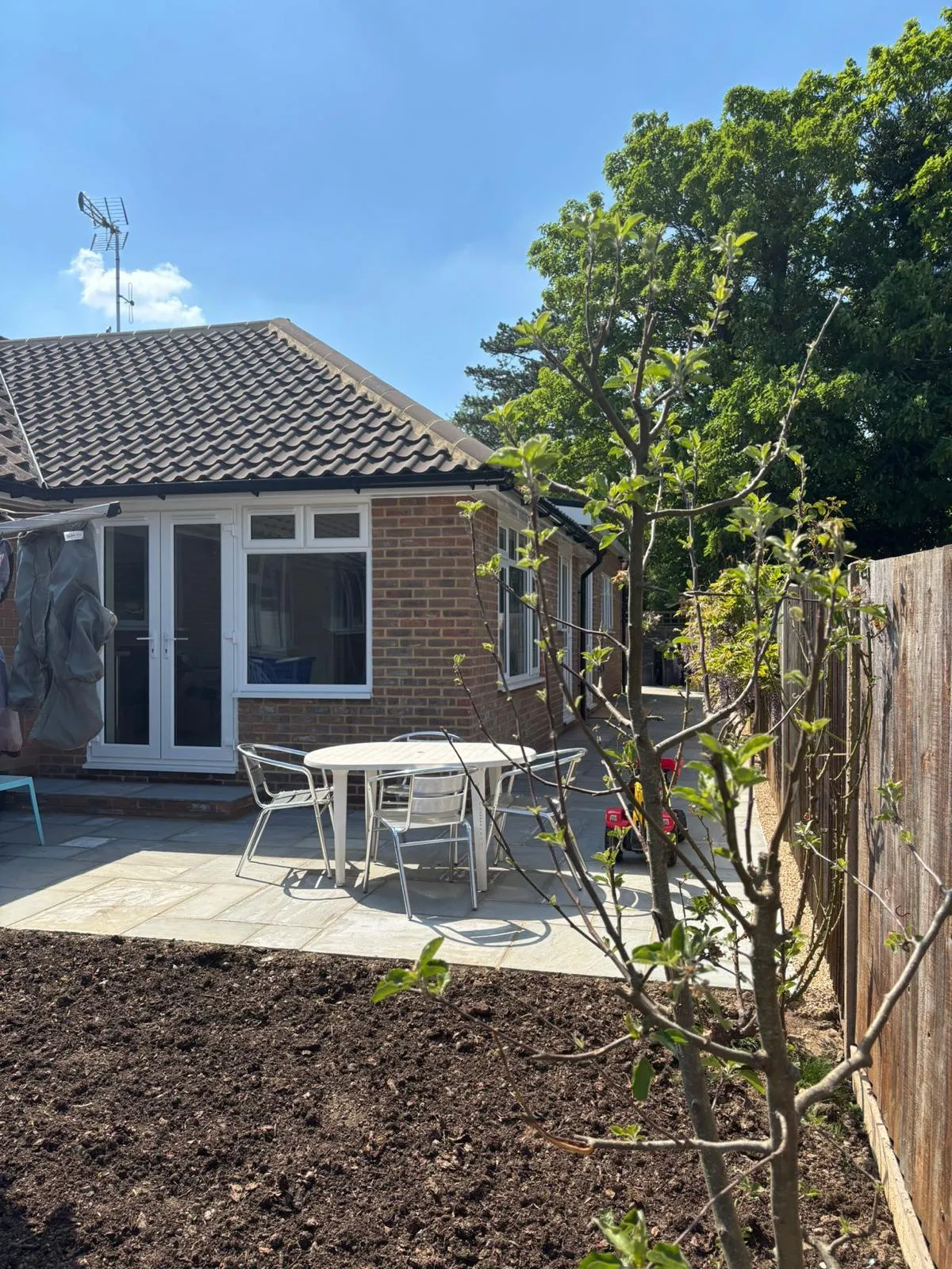 Brick bungalow extension with white French doors opening onto a new patio
