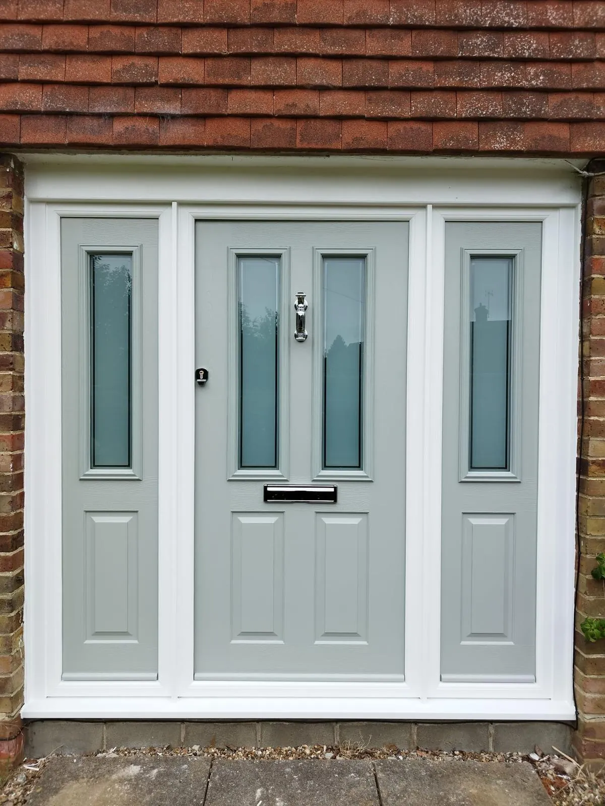 Pale grey-green composite front door with two glazed panels and matching glazed side panels