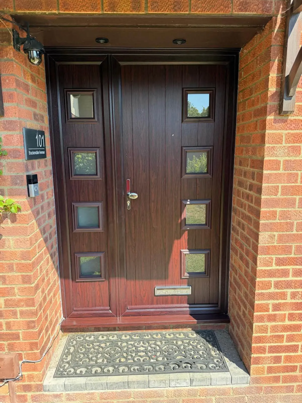 Rosewood composite door with square glazed panels and a matching side panel