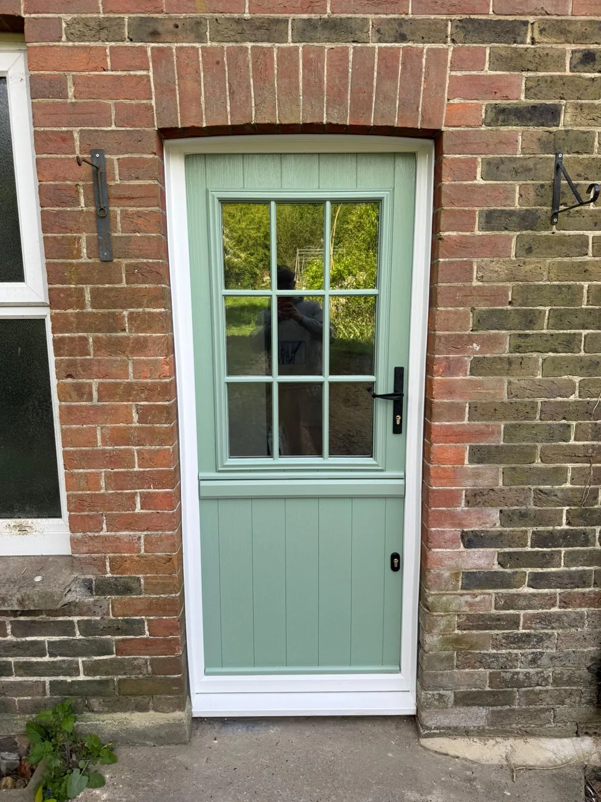 Chartwell green composite stable door with a Georgian-bar glazed top half