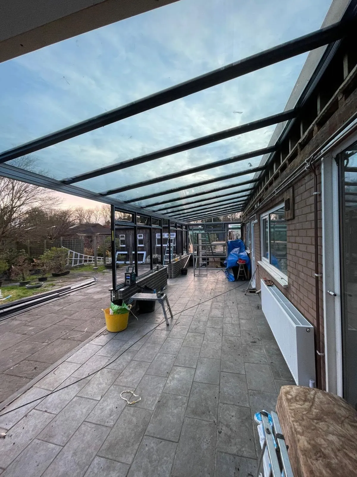 Glass veranda roof over a decked terrace alongside a house