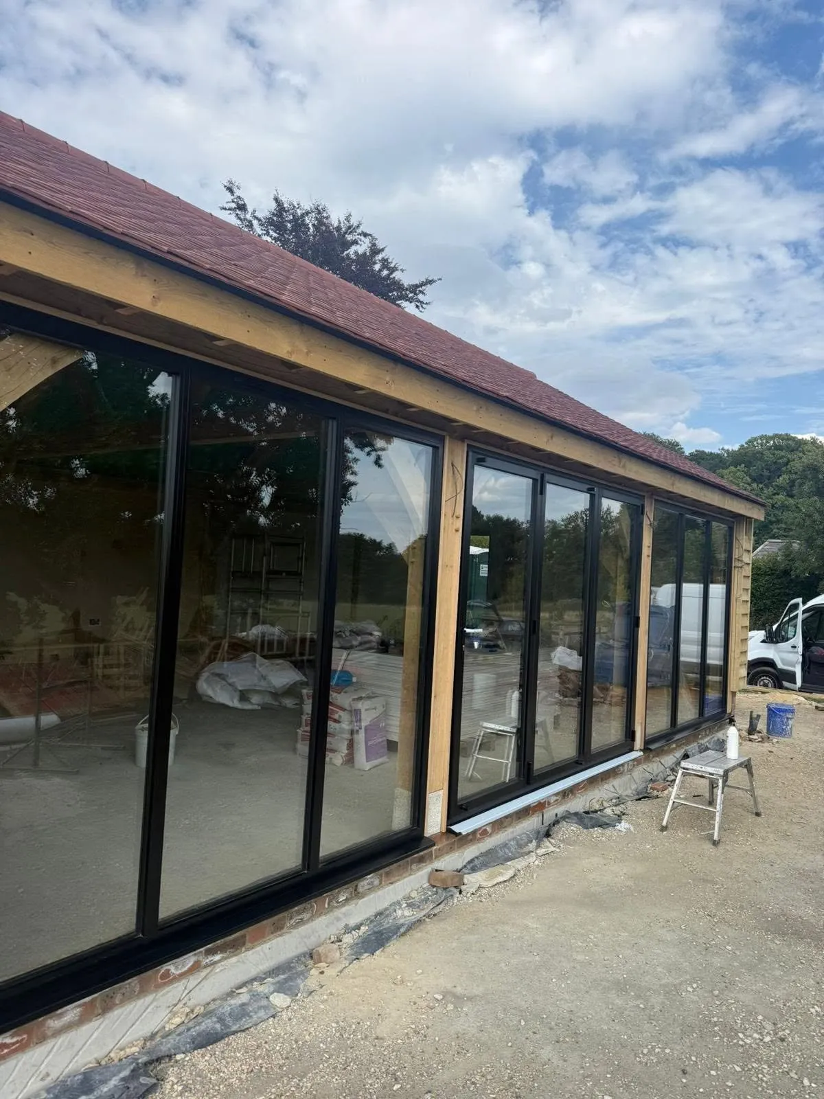 Glazed garden room with dark frames looking onto a garden