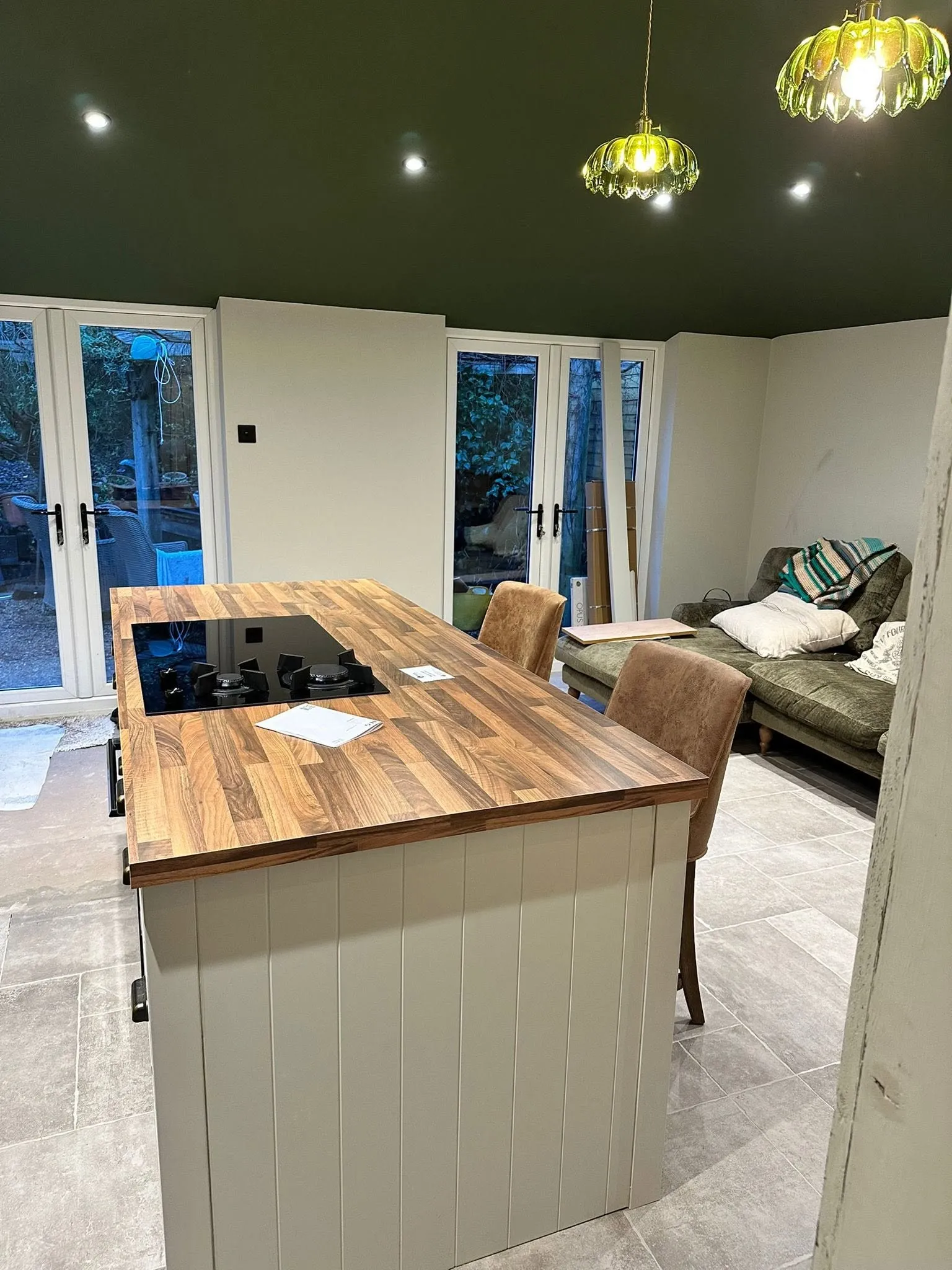 Fitted kitchen with a wood worktop against an exposed brick wall