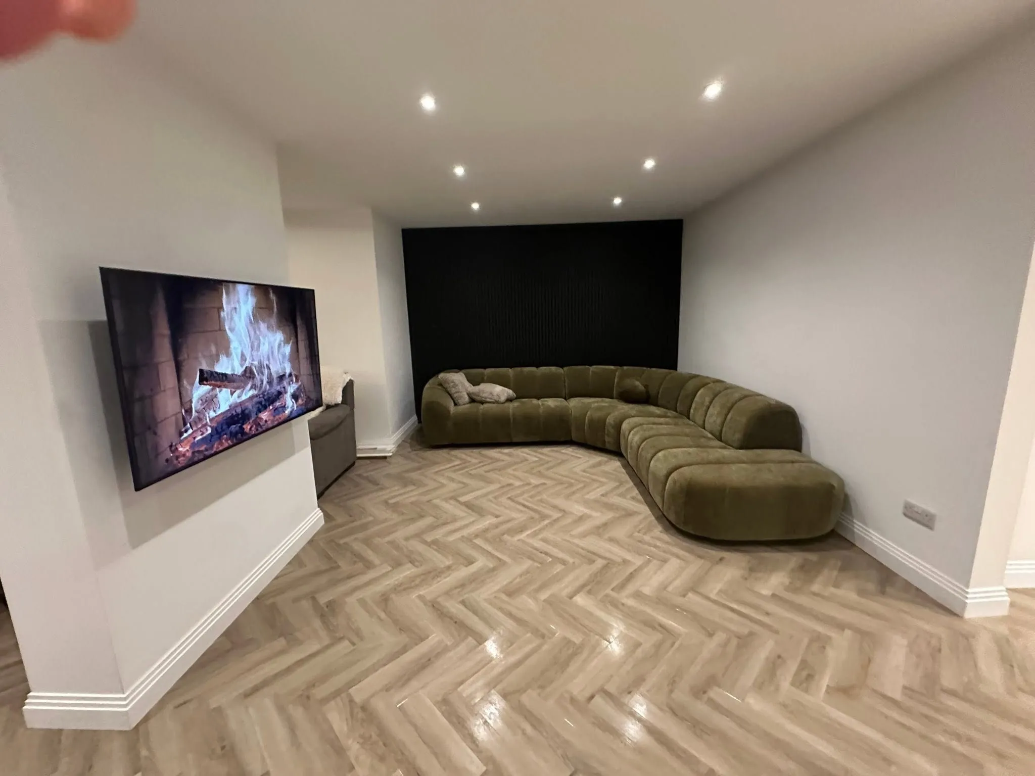 Living room with a herringbone floor and a panelled media wall