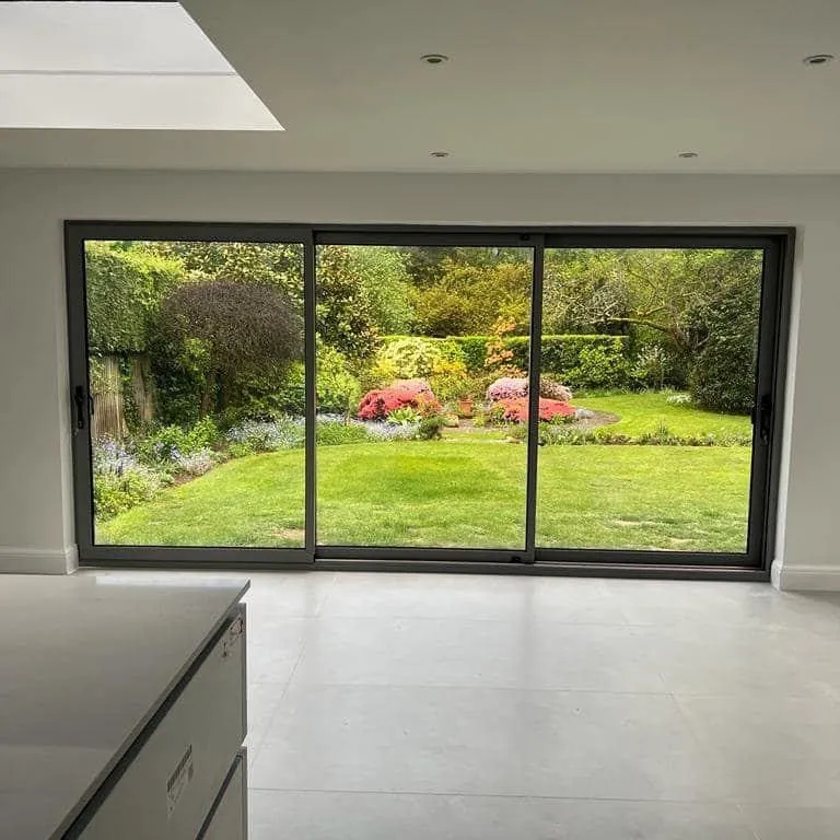 Open-plan extension with grey sliding doors onto the garden and a flat rooflight above