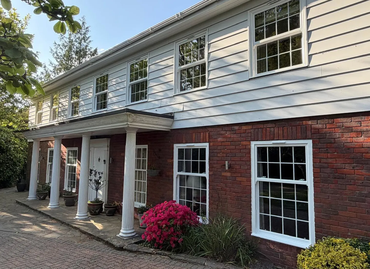 White sliding sash windows with Georgian bars on a colonnaded Sussex house