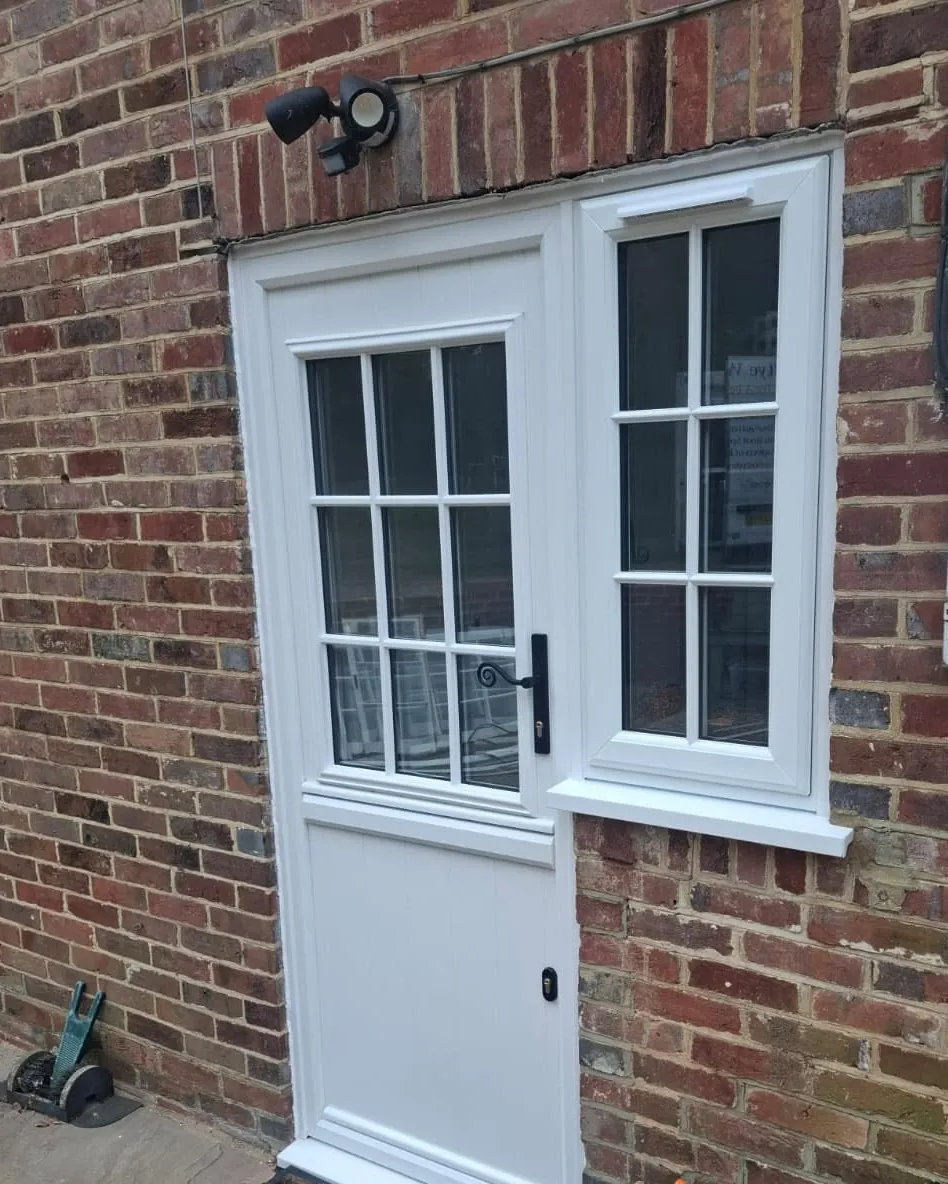 The same white stable door closed, with Georgian-bar glazing and a black monkey-tail handle