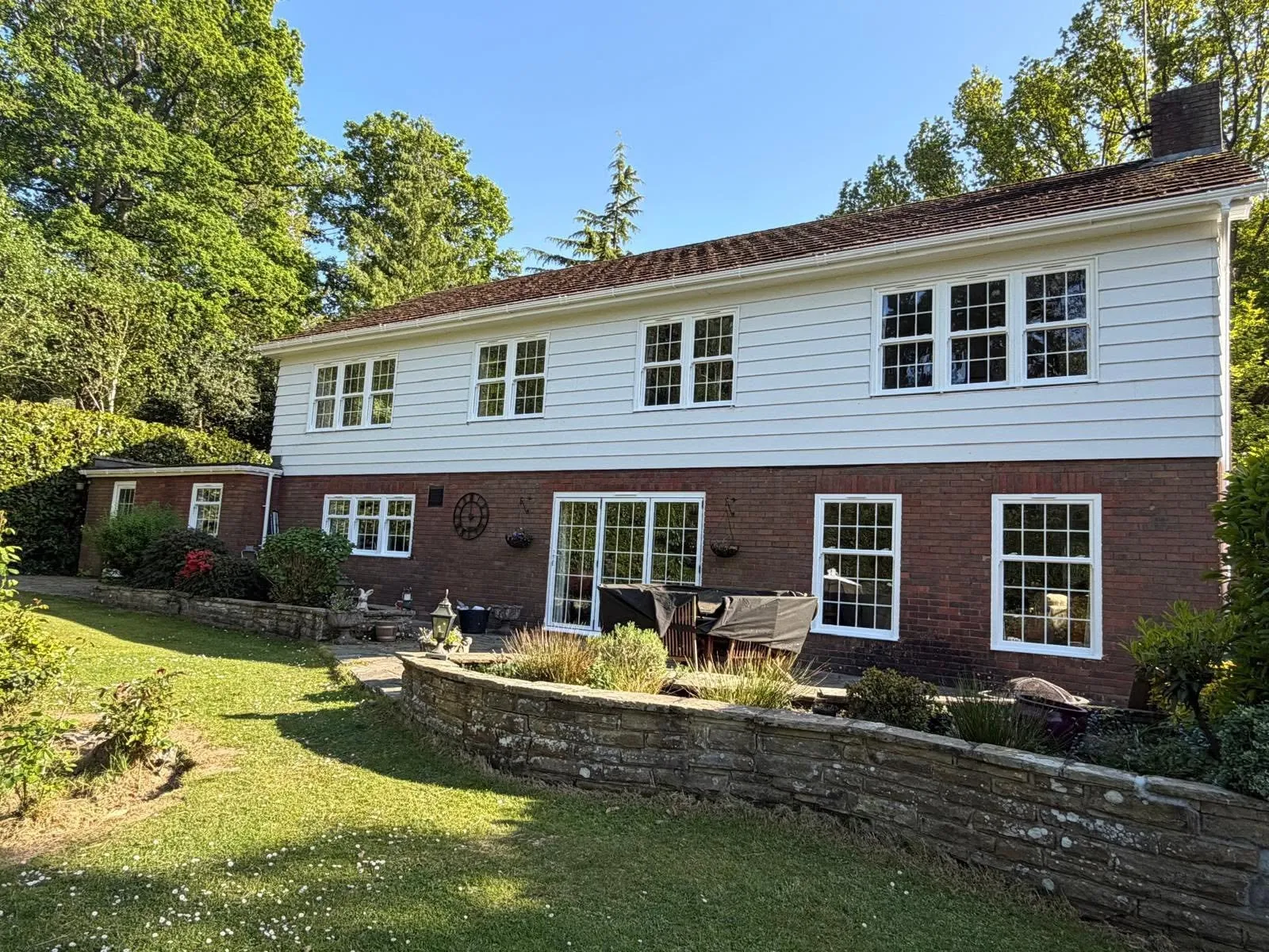 White windows with Georgian bars across the rear of a large detached house
