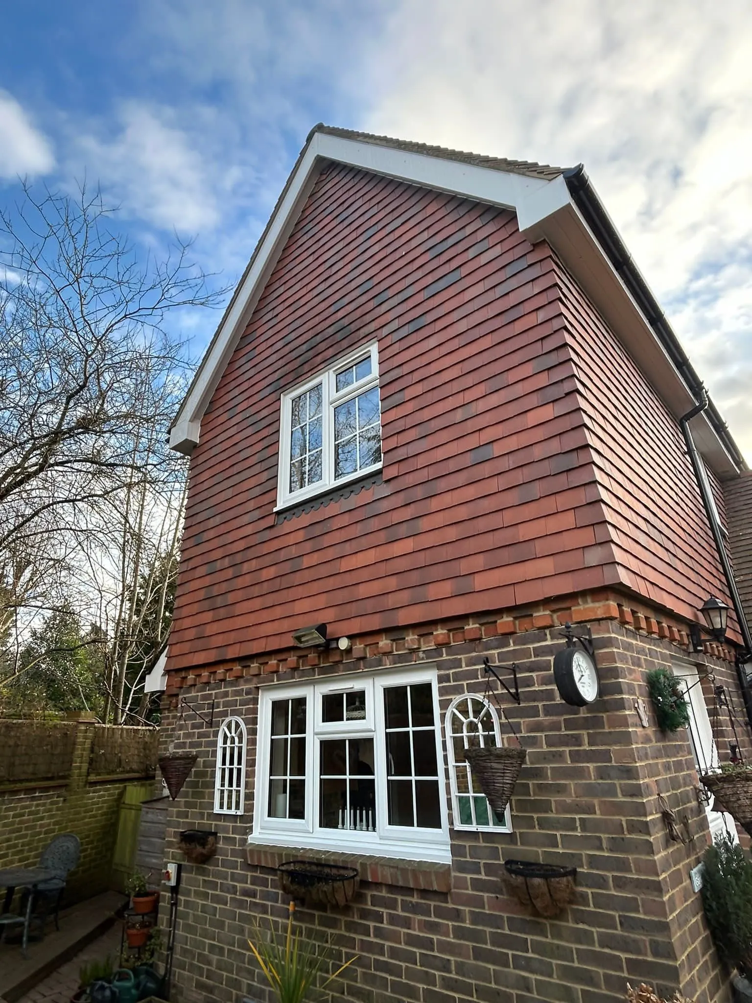 White bargeboards on a tile-hung gable with white Georgian-bar windows