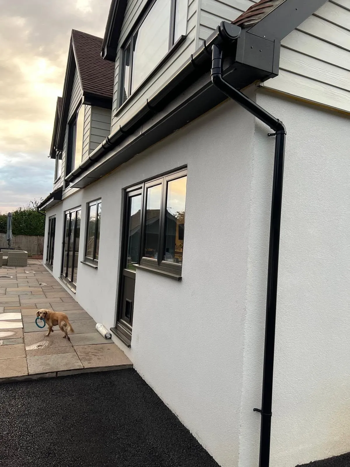 White rendered single storey extension with grey framed windows