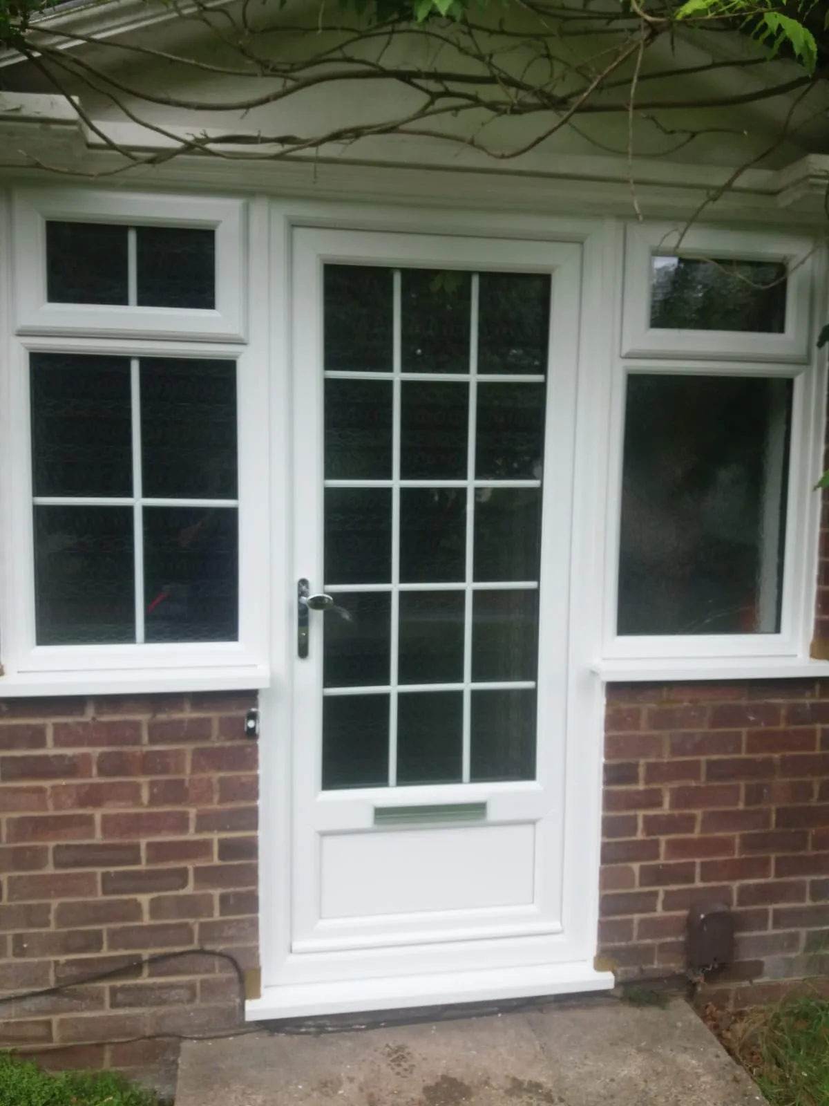 White uPVC door with Georgian bars and a window either side